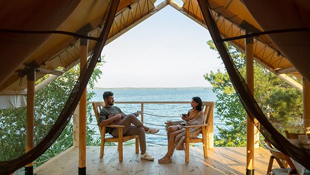 A couple enjoying a lakeside glamping trip.